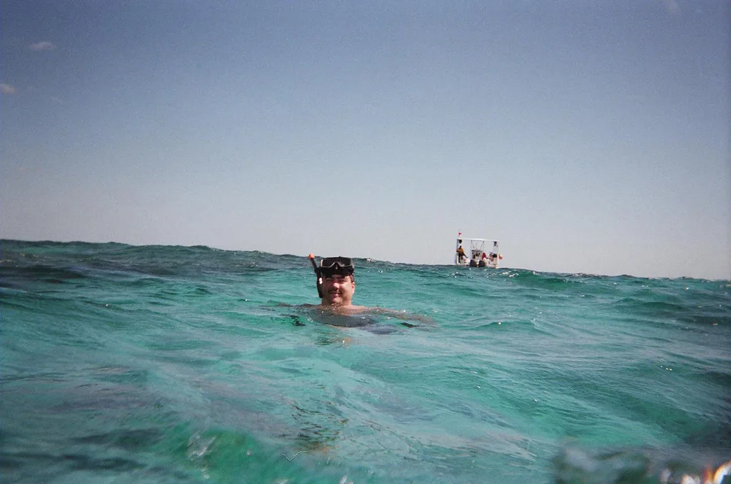 Snorkeler surfacing in clear water, Bahamas