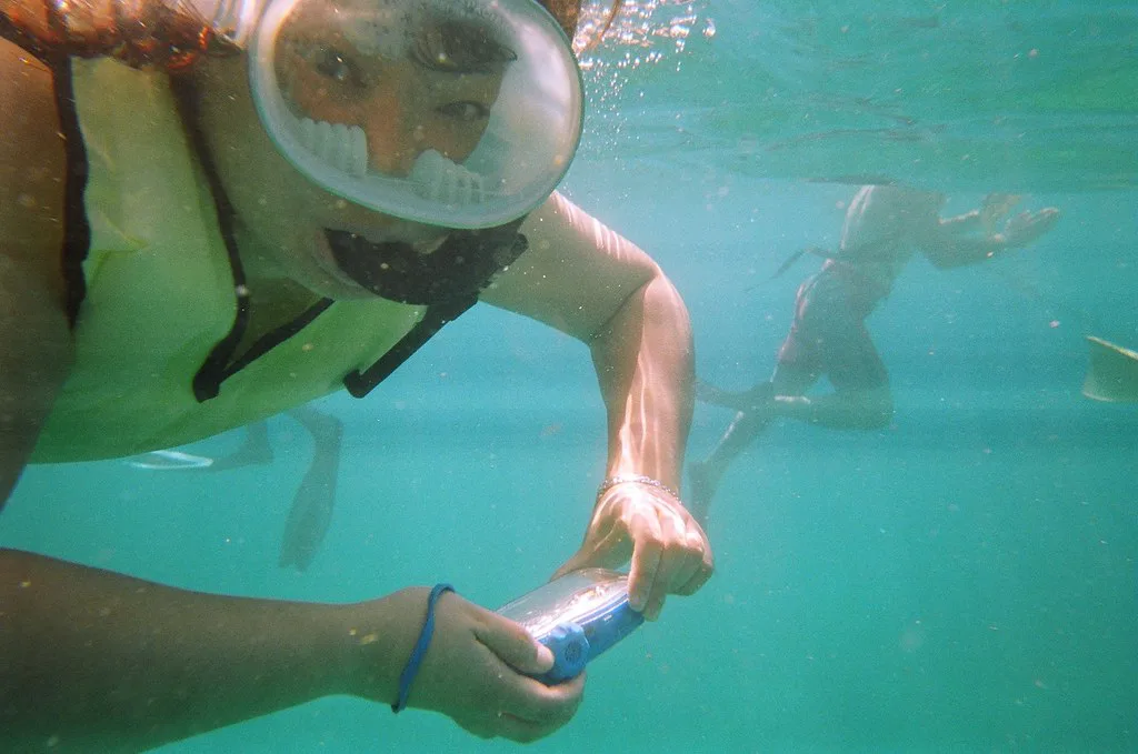 Snorkeler photographing reef life with an underwater camera, Florida