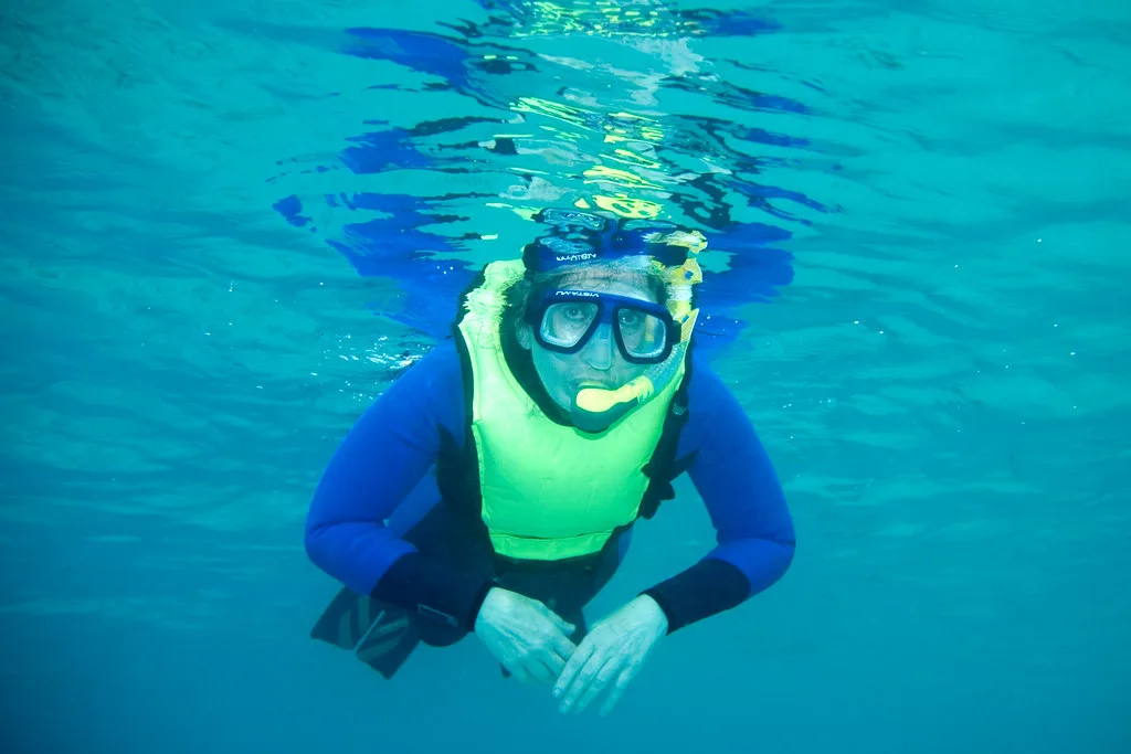 Snorkeler in clear water, illustrating snorkeling gloves